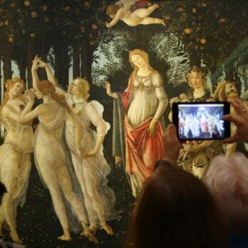 person taking a picture of a dancing women and men painting