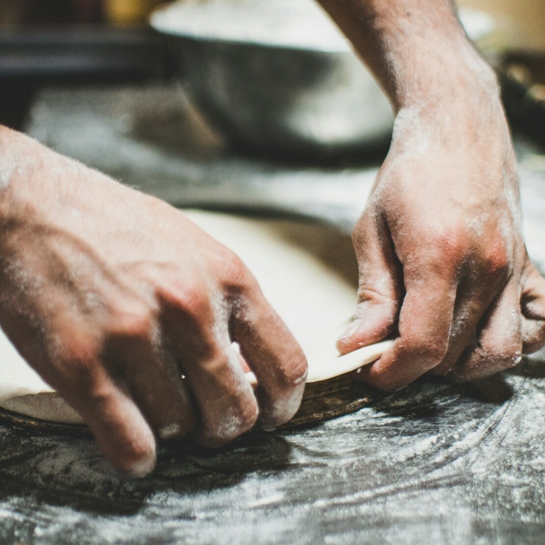 a person is kneading dough on a table