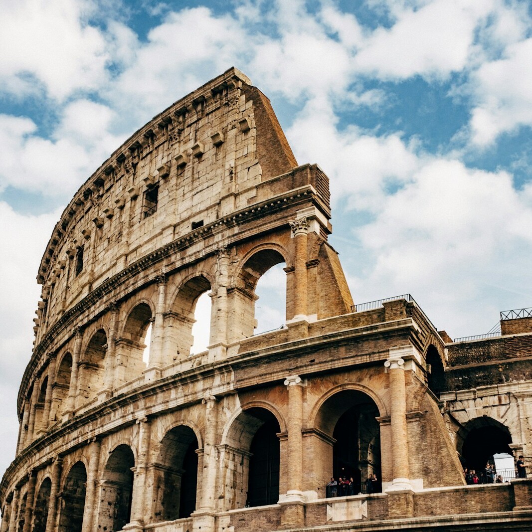 Colosseum under white clouds during daytime