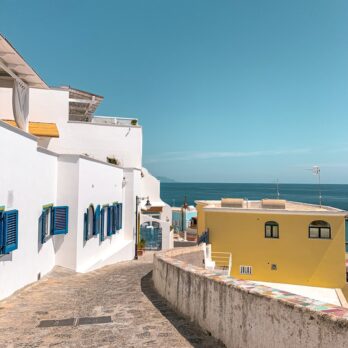white and blue concrete houses near sea during daytime