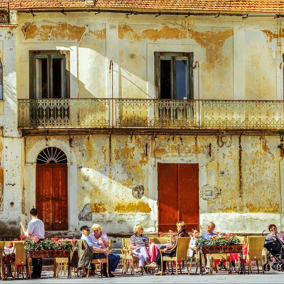 people sitting on chairs near brown concrete building during daytime
