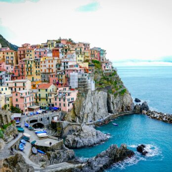 houses on cliff near body of water during daytime